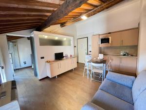 a living room with a couch and a kitchen at Guest House Delizia Estense in Ferrara