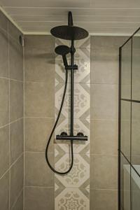 a shower in a bathroom with a tile floor at Naturnær leilighet med 2 soverom in Sandnes