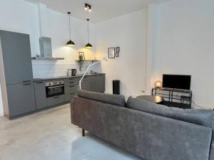 a living room with a couch and a kitchen at Trendy 2 Bedroom Serviced Apartment in Rotterdam