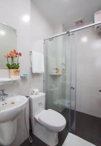 a white bathroom with a toilet and a shower at Ailen Garden 2 Hotel in Ho Chi Minh City