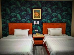 a bedroom with two beds and a green wallpaper at D'Borneo Hotel in Kota Kinabalu