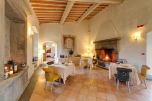 a restaurant with tables and chairs and a fireplace at Villa Tolomei Hotel & Resort in Florence