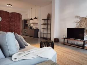 uma sala de estar com um sofá azul e uma televisão em Lovely 2 Bedroom Serviced Apartment in Rotterdam em Roterdã