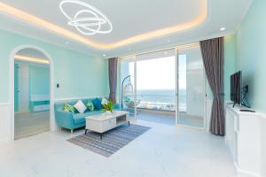 頭頓的住宿－Căn Hộ View Biển Santorini, Vũng Tàu，客厅配有蓝色的沙发和电视