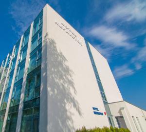 马马亚马马亚赫法伊斯托斯酒店的一栋高大的白色建筑，背景是蓝天