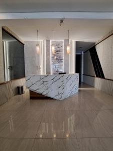 a lobby with a large marble counter in the middle at Hotel Sampurna Cirebon in Cirebon