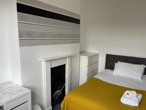 een slaapkamer met een bed en een open haard bij Golden Triangle Budget Rooms in Norwich