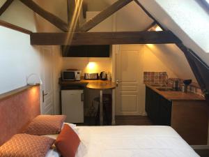 a room with a bed and a kitchen in a room at Appartement Domaine de la Freslonnière in Le Rheu