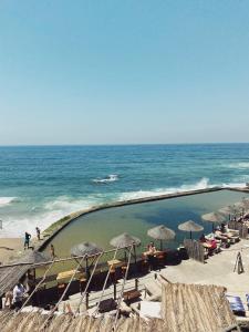 basen na plaży z parasolami i oceanem w obiekcie Azenhas do Mar Valley House w mieście Sintra