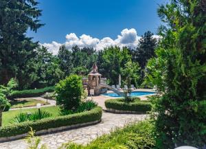 a garden with a house and a swimming pool at Spa Hotel Dvoretsa in Velingrad