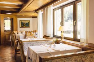 a dining room with tables and windows at Hotel Auren in San Giovanni in Val Aurina