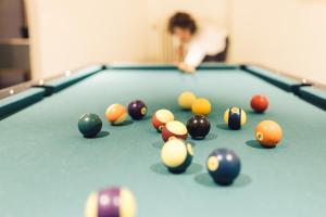 a woman playing a pool table with balls on it at Hotel Auren in San Giovanni in Val Aurina