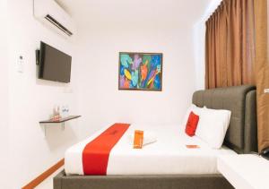 um quarto de hotel com uma cama e uma televisão em RedDoorz Plus at Palm Rise K Diving Resort Panglao Bohol em Panglao