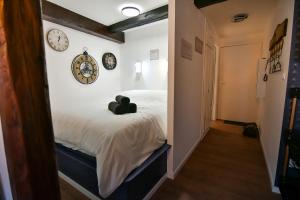 um quarto com uma cama com um relógio na parede em Au Fil du Temps em Sélestat