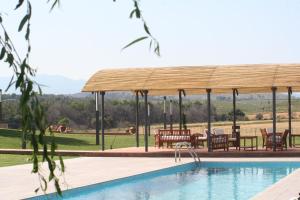 una piscina con cenador, mesa y sillas en Hotel Mas Oliveres Pla de Palau, en Llers