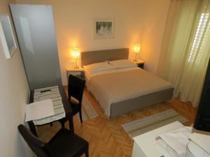a bedroom with a bed and a table and chairs at Apartments Staničić in Brela