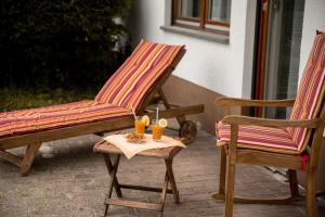 2 Stühle und ein Tisch mit Getränken auf der Terrasse in der Unterkunft Ferienwohnung Wald & Wild in Löffingen