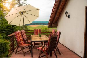 een tafel en stoelen met een parasol op een patio bij Ferienwohnung Wald & Wild in Löffingen