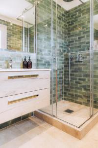 a shower in a bathroom with green tiles at Les Maisons Du Sud in Saint-Tropez