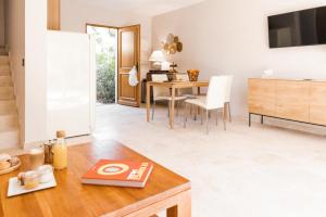 a kitchen and living room with a table and a dining room at Les Maisons Du Sud in Saint-Tropez