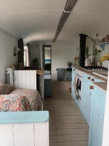 a room with a kitchen with a bed and a stove at Converted French bus with stunning views in Exeter