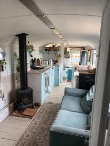 a living room with a couch and a stove in a van at Converted French bus with stunning views in Exeter