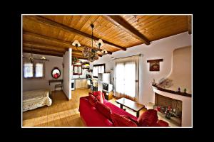 a living room with a red couch and a fireplace at Porto Katsiki Guest Houses in Athanion