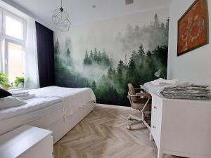 a bedroom with a bed and a desk in it at Bohema Apartement with private parking in Toruń