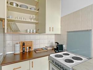 a kitchen with white cabinets and a stove top oven at 2BR Seafront Apt in center with community pool in Larnaca