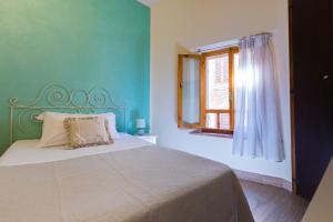 sypialnia z łóżkiem i oknem w obiekcie Affittacamere Mainardi 16 w mieście San Gimignano