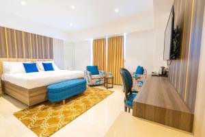 Habitación de hotel con cama y TV en The Thane Club, en Thane