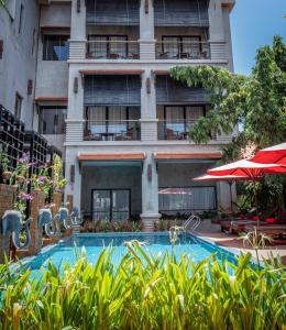 a hotel with a swimming pool in front of a building at Grange in Siem Reap