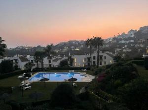duży basen z parasolami na dziedzińcu w obiekcie Marbella, Los Arqueros Golf & Country Club, Sleeps 7 plus 1 child w Marbelli