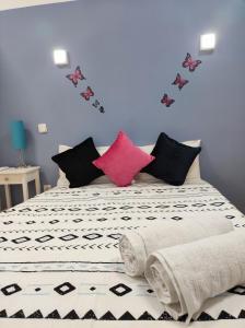1 cama con sábanas blancas y negras y almohadas rosas en LOFT PUERTA DE SOL, en Madrid