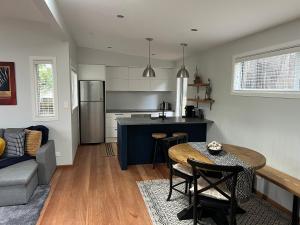 a kitchen and living room with a table and a couch at Torbay Tree Tops in Auckland