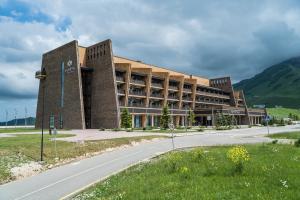 un gran edificio de ladrillo con una carretera delante de él en Shahdag Hotel & Spa en Shahdag