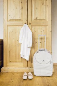 a suitcase and pair of shoes next to a door at Parkhotel Schachen in San Giovanni in Val Aurina