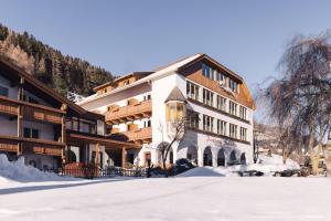 a large building with snow in front of it at Parkhotel Schachen in San Giovanni in Val Aurina