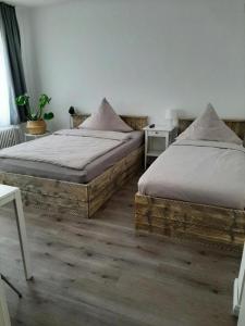 ein Schlafzimmer mit 2 Betten und einem Tisch mit einer Pflanze in der Unterkunft Pension Asche in Münster