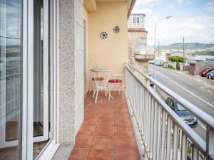 balkon ze stołem, krzesłami i ulicą w obiekcie PARAISO RIAS BAIXAS II Combarro w mieście Combarro