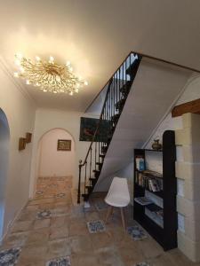 Habitación con escalera y lámpara de araña. en Maison sur le Lot, en Saint-Vincent-Rive-dʼOlt