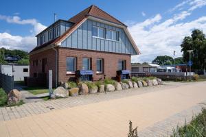 una casa con rocas delante de ella en Am Strande 31 Nixe, en Neustadt in Holstein