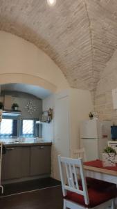 uma cozinha com uma mesa e uma cozinha com um frigorífico em L'Orecchietta em Ruvo di Puglia