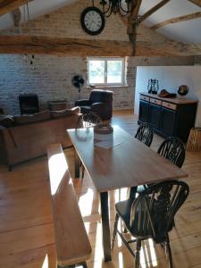 a living room with a wooden table and chairs at Gite Pays de Joie 