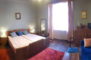 - une chambre avec un grand lit et une grande fenêtre dans l'établissement Josephine Central Villa & Garden, à Cluj-Napoca