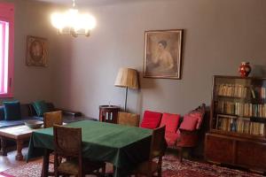 - un salon avec une table verte et des oreillers rouges dans l'établissement Josephine Central Villa & Garden, à Cluj-Napoca