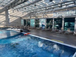 una grande piscina con sedie in un edificio di Appartement dans hôtel Pullman a Istanbul