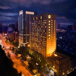 un edificio iluminado en una ciudad por la noche en Shangri-La Wuhan en Wuhan