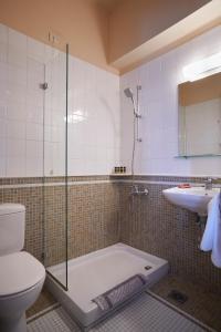 a bathroom with a shower and a toilet and a sink at Doma Hotel in Chania