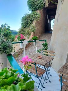 a wooden table and chairs on a balcony with flowers at BnB La Casina dei Nonni in Campofilone